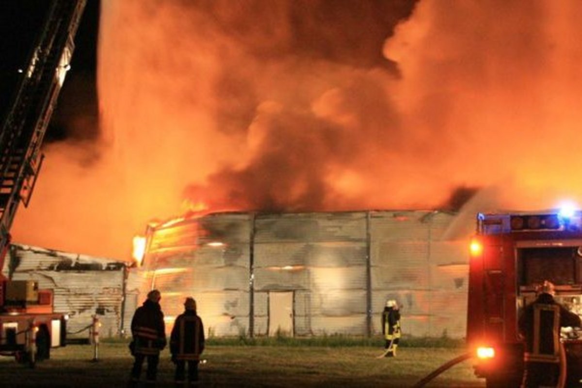 Feuerwehrauto vor orange schimmernden Qualmwolken